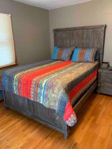 Schlafzimmer mit einem großen Bett mit einem Kopfteil aus Holz in der Unterkunft Whole Home MidCentury - Quiet & Close to Downtown in Des Moines