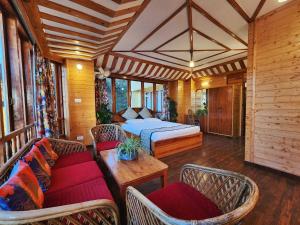 1 Schlafzimmer mit einem Bett, 2 Stühlen und einem Tisch in der Unterkunft Hotel Pineview Shimla in Shimla