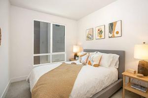 een witte slaapkamer met een bed en een raam bij Luxury NEW Residence with Private Rooftop, Downtown in minutes in San Diego
