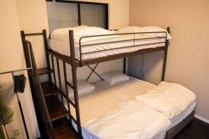 Un par de literas en una habitación en TasoneStayOsaka 心斎橋東周防町1st202, en Osaka 2 fotos más