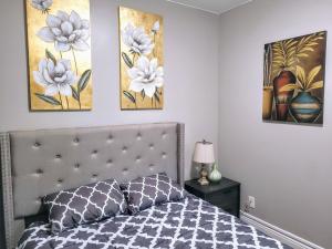 a bedroom with a bed and three paintings on the wall at Brand new house in downtown with parking in Buffalo