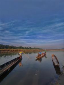 un grupo de personas en barcos en un río en Hotel Tharu Garden, Sauraha, en Sauraha