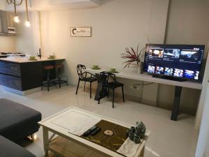a living room with a table and a large screen television at Brianna Balcony Apartment in Ban Ton Chok +12 photos