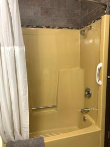 uma casa de banho com chuveiro e cortina de chuveiro em Bridge Inn Tomahawk -1st Floor, 2 Queen Size Bed, Walkout, River View em Tomahawk