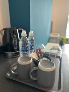 ein Tablett mit zwei Kaffeetassen und Wasserflaschen in der Unterkunft Castle Lodge in Nottingham