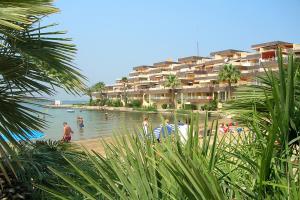 una playa con gente en el agua y un edificio en Ona Marina Arpón, en La Manga del Mar Menor