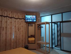a room with a television and a room with a bed at Posada Lindavista in Tulancingo