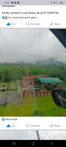 a window view of a house in the rain at Aliza Scawa Homestay in Kuala Pilah
