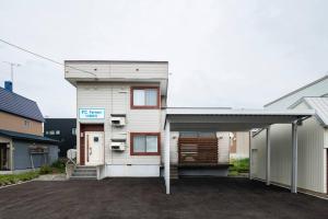 a white house with a garage in front of it at FC Farnest Niseko in Kutchan