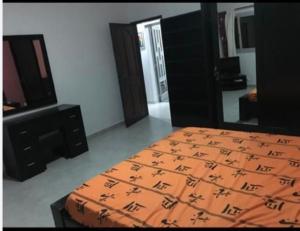 a bedroom with a bed with an orange comforter at joli appart F2 de 80m2 à liberté 6 extension in Dakar
