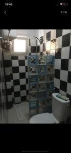 a bathroom with a toilet and a checkered wall at joli appart F2 de 80m2 à liberté 6 extension in Dakar