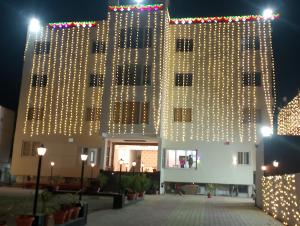 um edifício com luzes na lateral em Hotel Shanti International em Deoghar