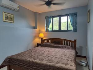 a bedroom with a bed and a ceiling fan at Seaview Eagles Nest Apartments in Rawai Beach