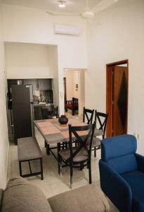 ein Wohnzimmer mit einem Tisch und Stühlen sowie eine Küche in der Unterkunft Departamento Villanueva 2. Depto. en Chetumal in Chetumal