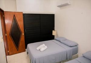 ein Schlafzimmer mit einem Bett mit zwei Handtüchern darauf in der Unterkunft Departamento Villanueva 2. Depto. en Chetumal in Chetumal