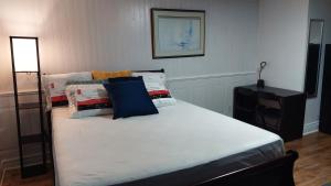 una cama con almohadas en una habitación en Comfy Rooms & Studio in 3Bed Home, en Timberlea