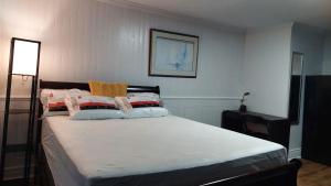 1 dormitorio con 1 cama grande con sábanas blancas en Comfy Rooms & Studio in 3Bed Home, en Timberlea