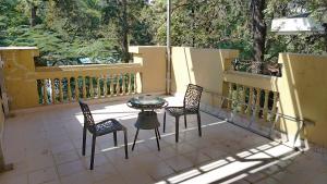 a patio with two chairs and a table on a balcony at HOTEL SWAASTIK in Pune