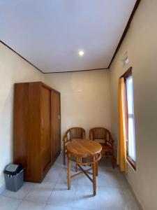 una camera con un tavolo in legno e due sedie di MALINI Homestay ad Ubud