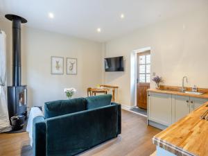 a living room with a couch and a kitchen at Peartree Cottage - Uk45496 