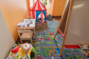um quarto para crianças com uma tenda de brinquedos no chão em Korona Hotel em Nyíregyháza