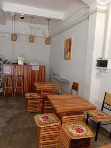 Habitación con mesas y sillas de madera y barra. en Annie Backpacker Hostel en Ban Nongdouang