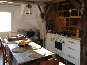 a kitchen with a table with plates of fruit on it at L'oisellerie Cottages in Le Renouard