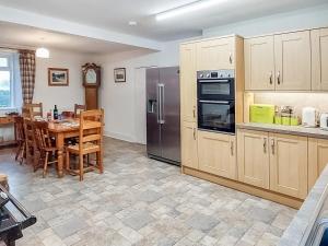 a kitchen with a table and stainless steel appliances at Culquhasen in Gillespie