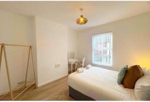 a bedroom with a large bed and a window at Large NEW House, Sleeps 10, FREE Parking, Near City Centre in Liverpool