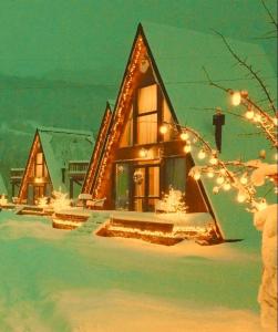 a house covered in christmas lights in the snow at WinterFell Mestia in Mestia