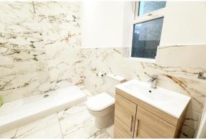 a bathroom with a toilet and a sink and a tub at Large NEW House, Sleeps 10, FREE Parking, Near City Centre in Liverpool