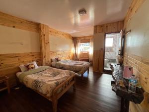 a bedroom with two beds and a table in it at Hotel Namche in Nāmche Bāzār
