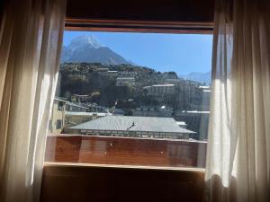 a window with a view of a mountain at Hotel Namche in Nāmche Bāzār