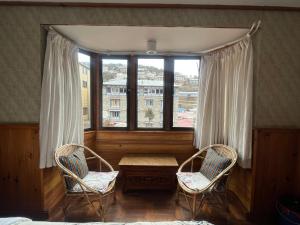 2 sillas y una mesa en una habitación con ventana en Hotel Namche, en Nāmche Bāzār