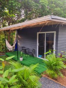 uma casa com uma rede de descanso e um pátio em CyKali Garden Bungalows em Wok Tum