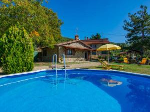 a large blue swimming pool in front of a house at BeB Il Poderino Family Room in Dicomano