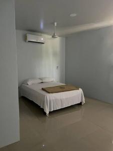 um quarto com uma cama num quarto branco em Apartamento cerca de Tamarindo em Villarreal
