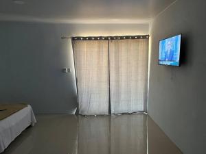 um quarto com uma cama e uma janela com uma televisão em Apartamento cerca de Tamarindo em Villarreal