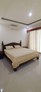 ein Schlafzimmer mit einem großen Bett in einem Zimmer in der Unterkunft Bejae Kummar Suite in Ubud