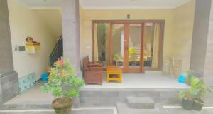ein Wohnzimmer mit Topfpflanzen und einer Tür in der Unterkunft Bejae Kummar Suite in Ubud
