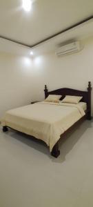 ein Schlafzimmer mit einem großen Bett in einem weißen Zimmer in der Unterkunft Bejae Kummar Suite in Ubud