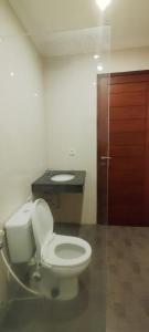 ein Badezimmer mit einem weißen WC und einem Waschbecken in der Unterkunft Bejae Kummar Suite in Ubud