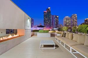 un patio con sofás y una chimenea con vistas al perfil urbano en DTLA Escape Skyline views with luxury amenities, en Los Ángeles