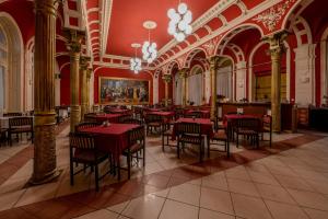 a restaurant with red tables and chairs in a building at Korona Hotel in Ny&iacute;regyh&aacute;za