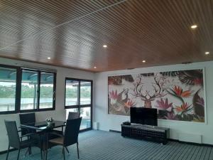 uma sala de estar com uma mesa e uma televisão em Crystal Beach Hotel em Port Vila