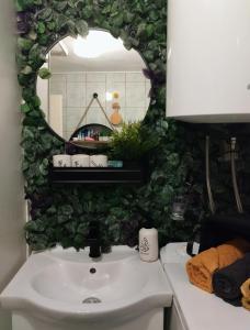 ein Badezimmer mit einem weißen Waschbecken und einem Spiegel in der Unterkunft Honey house Lika in Gospić