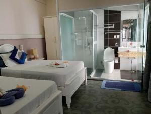 uma casa de banho com 2 camas e uma cabina de duche em vidro. em Crystal Beach Hotel em Port Vila