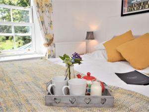 a tray with cups and flowers on a bed at 3 bed in Perranporth 57204 in Perranzabuloe