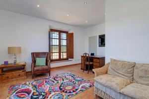 ein Wohnzimmer mit einem Sofa und einem Schreibtisch in der Unterkunft Cortijo Don Cristobal in Mollina