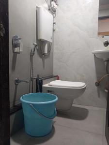 a bathroom with a toilet and a bucket at MY DORMITORY in Mumbai